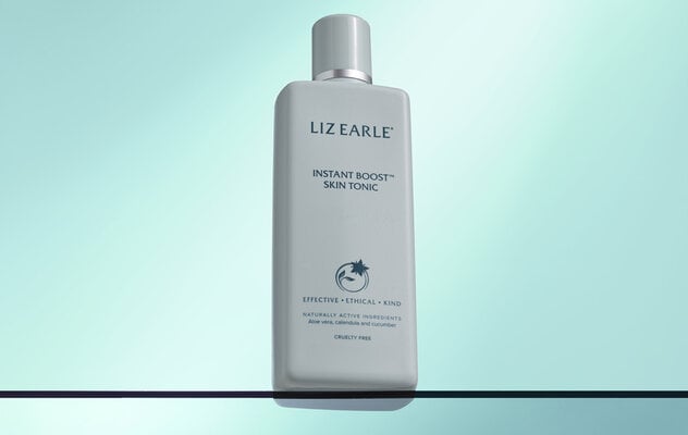 Instant Boost™ Skin Tonic Toner 200ml sat on a glass shelf on a light blue background