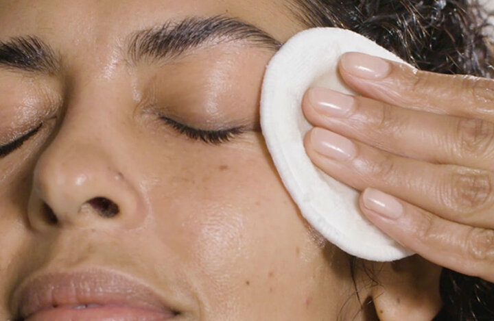 a woman using a cleanser around her eyes