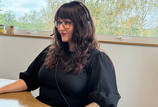Woman wearing a headset sitting at a desk