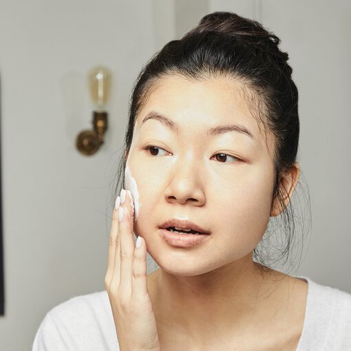 a woman using skincare products
