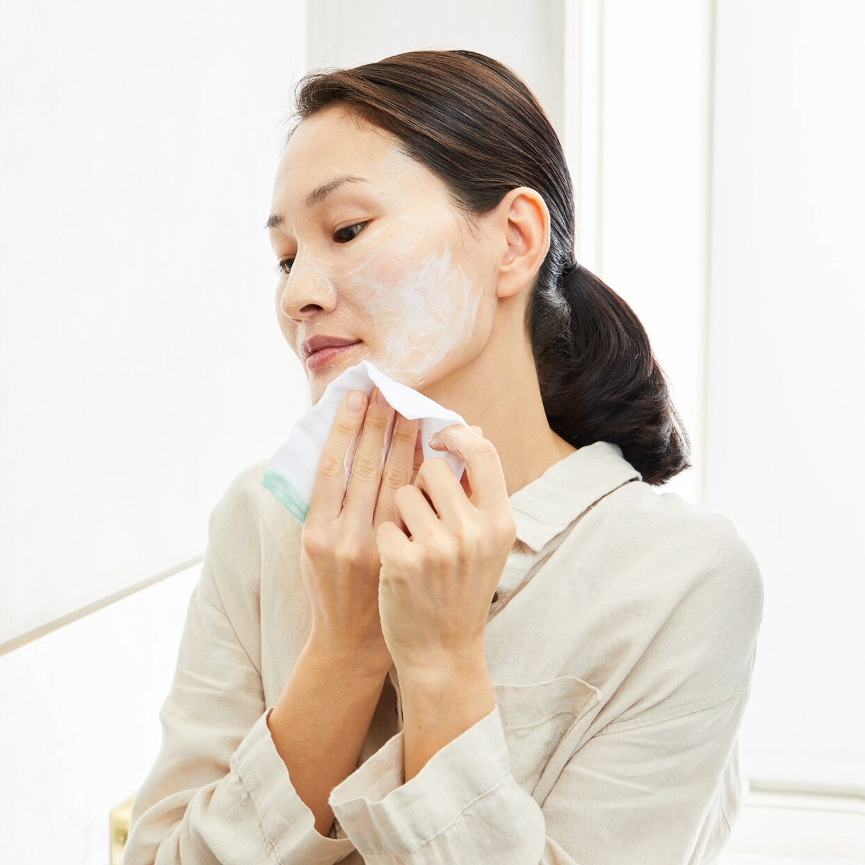 a woman applying a cleanser