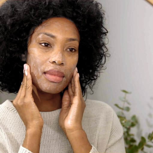a close up shot of a woman applying a skincare product