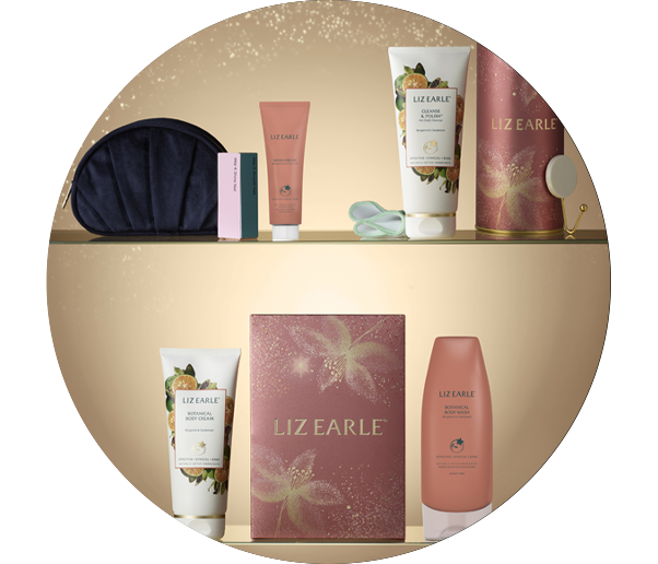 3 Liz Earle Christmas Gifts on a glass shelf on a gold background