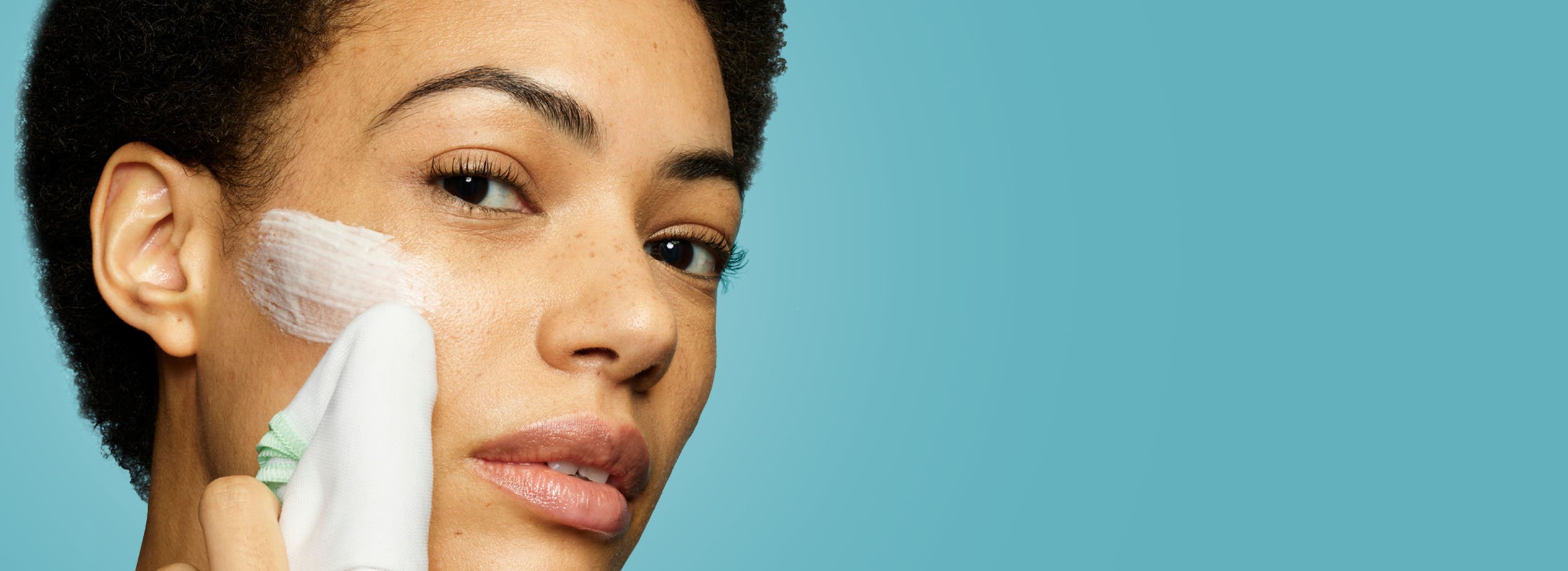 Liz Earle cleanser, moisturiser and instant skin boost tonic on a light blue background